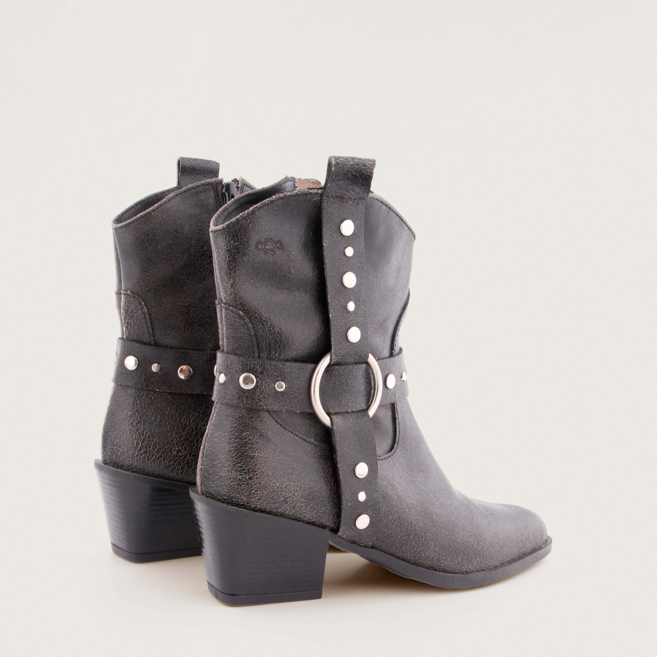 Black textured leather western-style ankle boot with metal ring and studded strap by AQA, model Sofia.